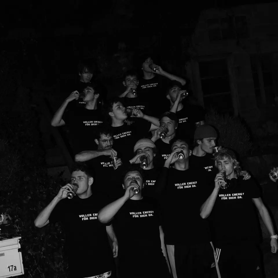 Die ganze Gruppe nachts vor dem Haus, alle mit einer Dose in der Hand